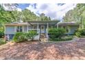 Inviting covered front porch with swing and seating, leading to the home's entrance with steps and garden at 1588 Peachtree Cir, Lawrenceville, GA 30043