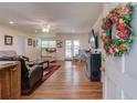 Spacious living room with hardwood floors, a large wreath, and access to the outdoor patio at 1588 Peachtree Cir, Lawrenceville, GA 30043