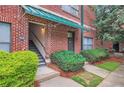 Exterior building entrance with a staircase, greenery, and brick facade with a green awning at 791 Wylie Se St # 410, Atlanta, GA 30316