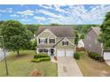 Aerial view of a two-story home featuring a well-manicured lawn and mature trees at 216 Toonigh Way, Canton, GA 30115