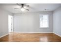 Spacious bedroom with hardwood flooring, large window, neutral paint, and ceiling fan with light at 2928 George Busbee Pkwy, Kennesaw, GA 30144