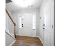 Bright entryway featuring hardwood floors, a white front door flanked by windows, and staircase with white railing at 2928 George Busbee Pkwy, Kennesaw, GA 30144