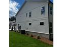 Side view of the townhome showing the white siding and brick foundation at 4180 Cavalier Way, Duluth, GA 30097