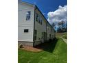 Side view of a townhome featuring white siding and well-maintained landscaping at 4180 Cavalier Way, Duluth, GA 30097