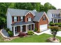 Attractive two-story brick home with black shutters, covered porch, and landscaped front yard at 4613 Creek Forest Ct, Lilburn, GA 30047