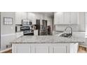 Bright kitchen featuring white cabinets, stainless appliances, and granite countertops at 6119 Fairlong Nw Run, Acworth, GA 30101