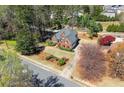 Aerial shot of brick home showcasing well-maintained lawn, mature trees and landscaping at 13090 Magnolia Crescent Dr, Roswell, GA 30075