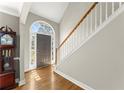 Bright foyer with hardwood floors and a staircase featuring white railings at 13090 Magnolia Crescent Dr, Roswell, GA 30075