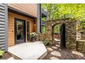 Welcoming front entrance featuring a stone archway, wood accents, and a stylish black-trimmed door at 4052 Loch Highland Ne Pass, Roswell, GA 30075