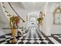 Elegant foyer with black and white tile flooring, curved staircase, and ornate decor at 675 W Paces Ferry Nw Rd # 11, Atlanta, GA 30327