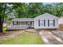 Charming single-story home with a covered porch, gray siding, and driveway leading to the house at 7845 Chase Woods Dr, Jonesboro, GA 30236