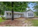 Inviting one-story home boasts a covered porch and well-maintained landscaping in a serene, wooded neighborhood at 7845 Chase Woods Dr, Jonesboro, GA 30236