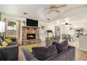 Cozy living room features a stone fireplace, tile floors, ceiling fans, and comfortable seating for relaxing at 7845 Chase Woods Dr, Jonesboro, GA 30236