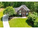Expansive front lawn with circular driveway leading to a two-story brick home with mature trees at 213 Shady Valley Dr, Carrollton, GA 30116