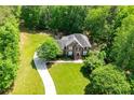 Lush trees surround two-story brick home featuring long drive and expansive green lawn at 213 Shady Valley Dr, Carrollton, GA 30116