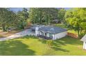 Aerial view of a well-kept one-story house with a spacious lawn and mature trees at 4166 Idlevale Dr, Tucker, GA 30084