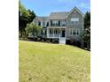Traditional two-story home boasting stone accents, a front porch, and a well-manicured lawn at 6945 Autumn Hills Dr, Cumming, GA 30028