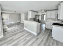 Open-concept living space with updated flooring, stainless steel appliances, and a breakfast bar at 6945 Autumn Hills Dr, Cumming, GA 30028