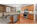 Stylish kitchen featuring granite countertops, stainless steel appliances, and wooden cabinets at 3524 Old Towne Ln, Cumming, GA 30040