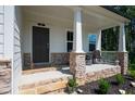 Inviting front porch with stone details, a comfortable seating area, and charming outdoor decor at 63 Brookstone E Park, Acworth, GA 30101