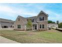 An attractive new home featuring mixed brick and siding and a neatly landscaped lawn at 234 Linford Dr, Locust Grove, GA 30248