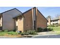 Brick townhome featuring mature landscaping, visible windows, and a well-maintained exterior at 3268 Clairmont Ne, Brookhaven, GA 30329