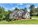 Beautiful home featuring a stone and painted facade, professional landscaping, and a sprawling green lawn at 104 Meadow View Trl, Canton, GA 30115