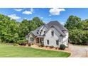 Attractive home with painted facade and stone accents complemented by a well-manicured lawn and mature trees at 104 Meadow View Trl, Canton, GA 30115