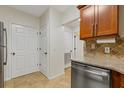 Galley kitchen featuring stainless steel dishwasher, granite countertops, and tile backsplash at 3334 Peachtree Ne Rd # 101, Atlanta, GA 30326