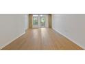 Bright living room boasting beautiful wood floors and a sliding glass door leading to a balcony at 3334 Peachtree Ne Rd # 101, Atlanta, GA 30326
