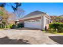 A brick two car garage with beautiful white doors situated near a well maintained yard at 1019 Henna Se Ct, Conyers, GA 30013