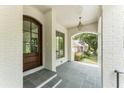 Inviting front porch with stone flooring, brick columns, and a wooden front door at 1211 Reeder Ne Cir, Atlanta, GA 30306
