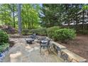 Serene backyard patio with stone pavers, retaining wall, seating, and lush landscaping for outdoor relaxation at 3298 Robinson Oaks Ne Way, Marietta, GA 30062