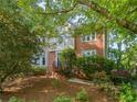 Two-story traditional brick home with mature trees providing shade on a sunny day at 3298 Robinson Oaks Ne Way, Marietta, GA 30062