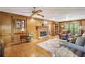 Cozy living room features wood paneled walls, brick fireplace, and hardwood floors at 3298 Robinson Oaks Ne Way, Marietta, GA 30062