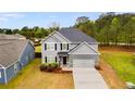 Two-story home with a gray exterior, black shutters, landscaped front yard, and an attached two-car garage on a sunny day at 209 Shelton Cir, Temple, GA 30179