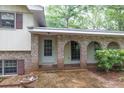 Inviting covered front porch featuring brick arches, providing shade and character to the entrance of this charming property at 2288 Hudson Sw Dr, Lilburn, GA 30047