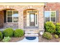Inviting front porch with stone accents and a stylish front door with sidelights at 4041 Woodward Walk Ln, Suwanee, GA 30024