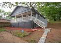 Side view of a gray home showing a porch with white railing and landscape with an ADT security sign at 1889 Vesta Ave, Atlanta, GA 30344