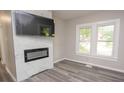 Bright living room featuring a modern fireplace, stylish gray flooring, and natural light from the windows at 1889 Vesta Ave, Atlanta, GA 30344