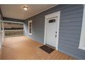 Covered front porch with a wood floor, white railing, and a view of the front door with the house number at 1889 Vesta Ave, Atlanta, GA 30344