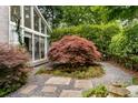 Exterior image showcases lush landscaping, a red Japanese maple, and decorative stone, creating a serene outdoor space at 318 5Th Ne St, Atlanta, GA 30308