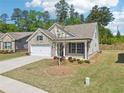 Wide shot of a single-story brick home with landscaped yard, two-car garage, and charming architectural details at 3382 Long Creek Dr, Buford, GA 30519
