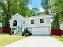 Charming two-story home with a manicured lawn, a garage, and beautiful landscaping at 8399 Lake Dr, Snellville, GA 30039
