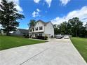 Two-story home featuring a well-manicured lawn and long driveway at 13 Four Feathers Ln, Rydal, GA 30171