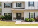 Inviting front entrance with a glass-paneled door, stone accents, and well-maintained landscaping at 13 Four Feathers Ln, Rydal, GA 30171
