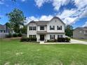 Traditional two-story home with a well-maintained lawn and landscaping at 13 Four Feathers Ln, Rydal, GA 30171