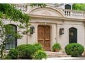 A detailed shot of the front entrance with wooden doors, sconces, and manicured greenery at 3212 Arden Nw Rd, Atlanta, GA 30305
