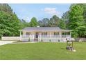 Inviting home featuring a wide front porch and well-manicured lawn at 37 Winesap Ct, Temple, GA 30179