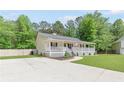 View of a well-maintained ranch home featuring a classic white porch and ample parking at 37 Winesap Ct, Temple, GA 30179